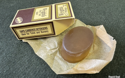 Handmade light brown oval shaped soap wrapped in parchment paper and packed in a vintage 1940’s reproduction box.