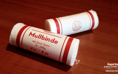 Simple medical bandage, rolled in paper wrapper with printed information: 4m length, 8cm width.